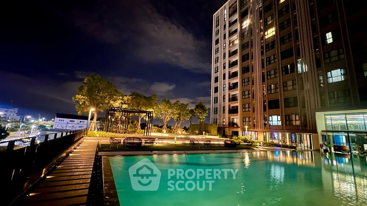 Luxurious high-rise building with illuminated pool and lush garden at night, offering serene urban living.