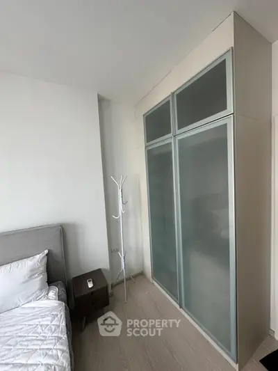 Modern bedroom with sleek frosted glass wardrobe and minimalist decor