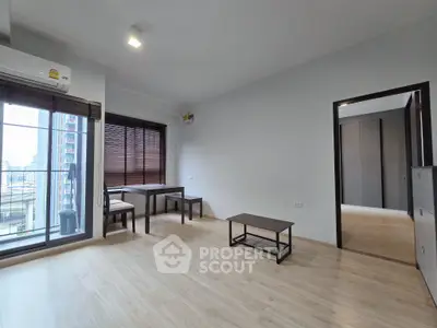Modern living room with wooden flooring and city view from window.