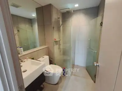 Modern bathroom with glass shower and sleek fixtures in a contemporary apartment.