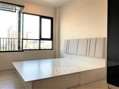 Modern minimalist bedroom with large window and city view