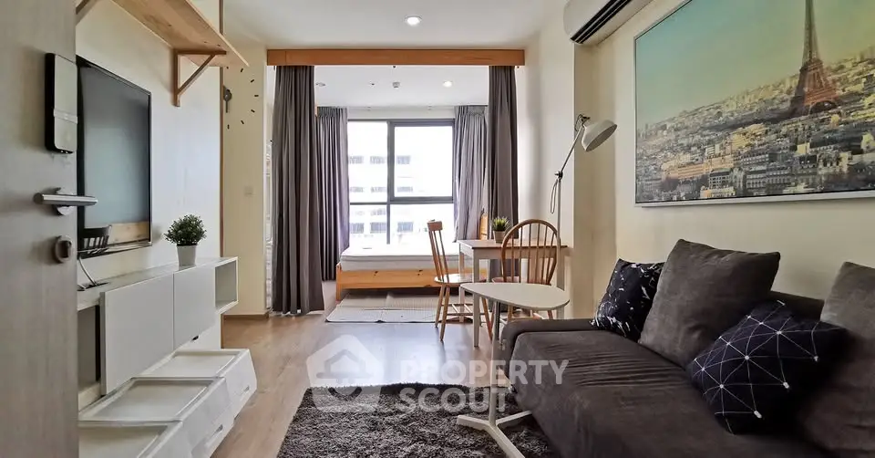 Chic modern living room with cozy seating and stylish decor, featuring a large window with city view.