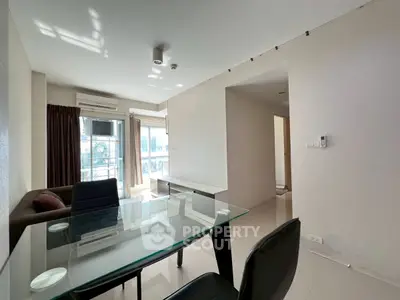 Modern living room with glass dining table and natural light in urban apartment