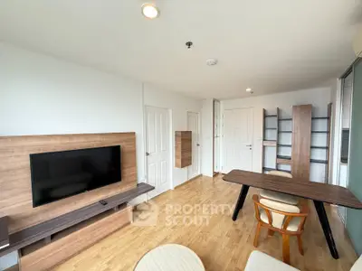 Modern living room with wooden flooring, sleek TV setup, and stylish dining area.