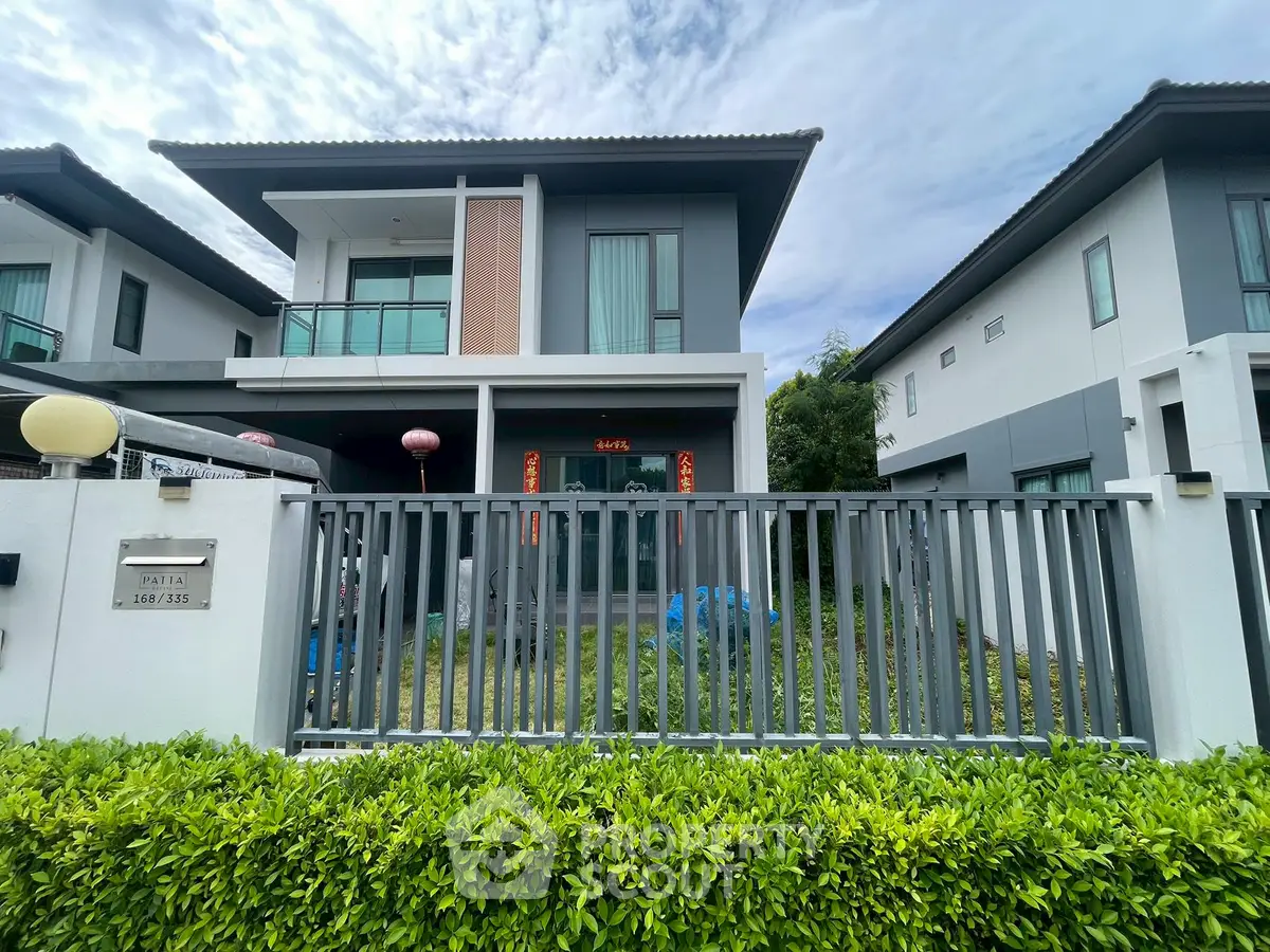 Modern two-story house with sleek design and lush greenery in a serene neighborhood.
