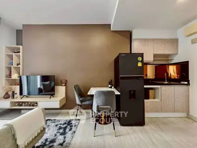 Modern open-plan living room with stylish kitchen and dining area, featuring sleek furniture and contemporary decor.