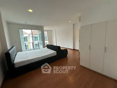 Spacious bedroom with modern design and balcony access in a stylish apartment.