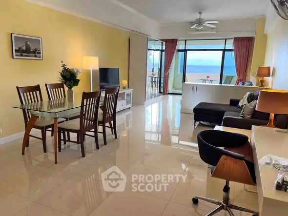 Spacious living room with ocean view, modern furniture, and elegant decor in a beachfront apartment.