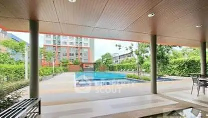 Luxurious apartment complex with a stunning pool and lush greenery.