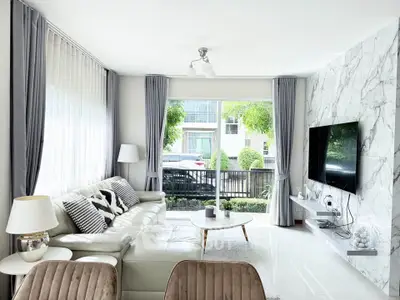 Modern living room with marble accent wall and large windows