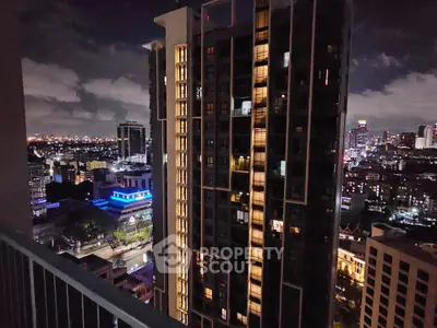 Stunning night cityscape view from high-rise balcony overlooking illuminated skyline.
