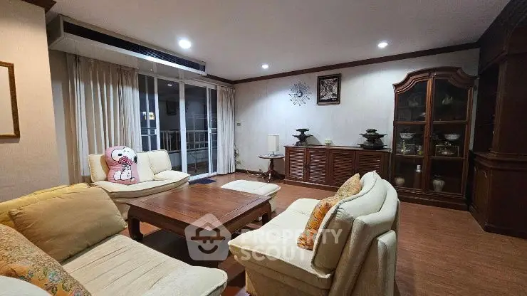 Spacious living room with elegant wooden furniture and cozy seating area.