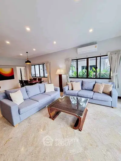 Spacious living room with modern decor and large windows for natural light.