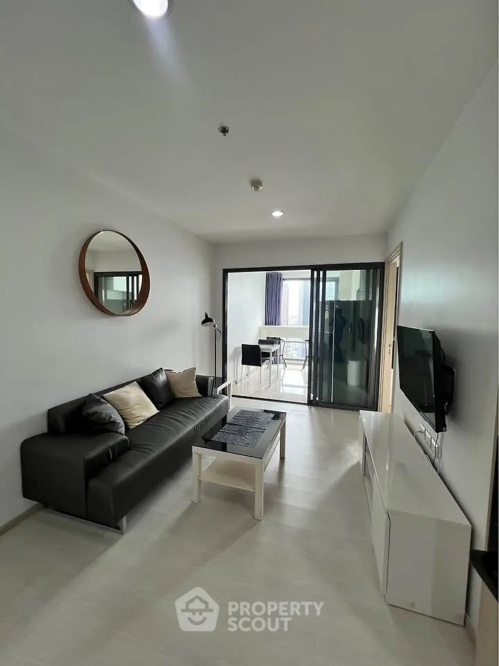 Modern living room with sleek furniture and balcony view, perfect for urban living.