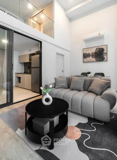 Modern living room with stylish sofa, open kitchen, and elegant decor in a contemporary apartment.