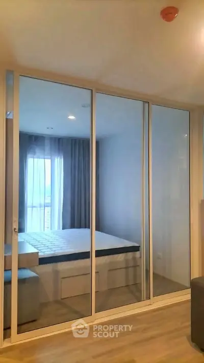 Modern bedroom with mirrored sliding doors and natural light