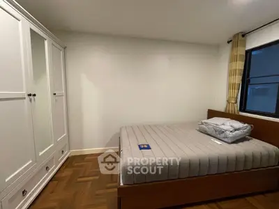 Cozy bedroom with wooden flooring and large wardrobe