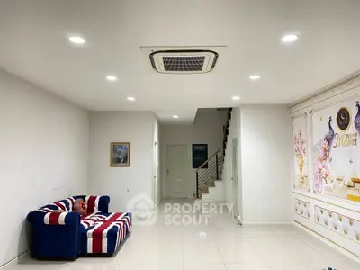 Spacious living room with modern decor and unique wall art, featuring a stylish sofa and elegant lighting.