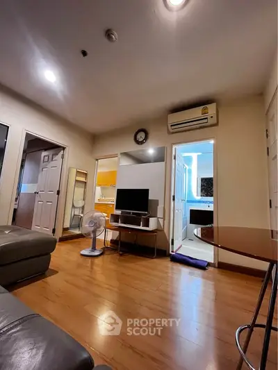 Cozy living room with wooden flooring, modern furniture, and air conditioning in a stylish apartment.
