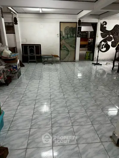 Spacious tiled room with vintage decor and ample natural light, ideal for versatile living space.