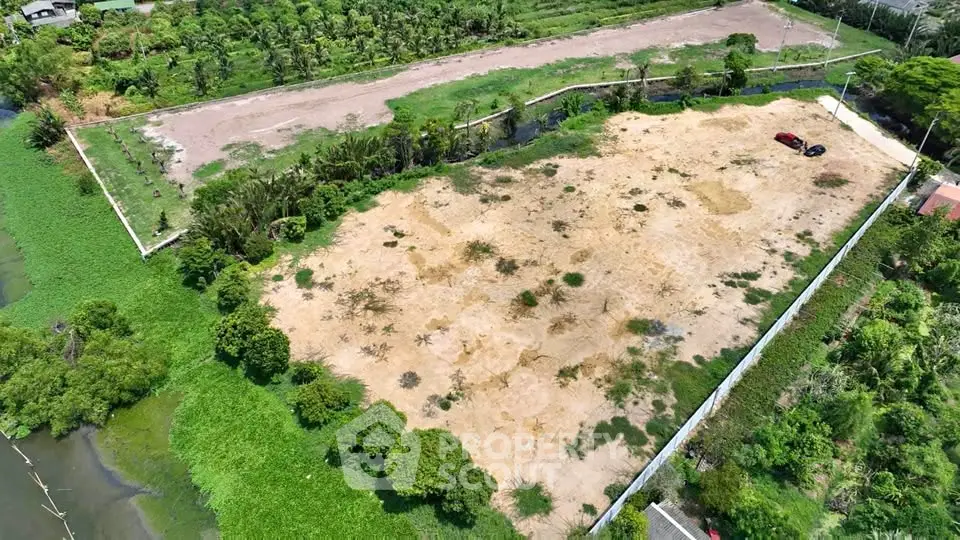 Expansive vacant land plot surrounded by lush greenery, ideal for development opportunities.