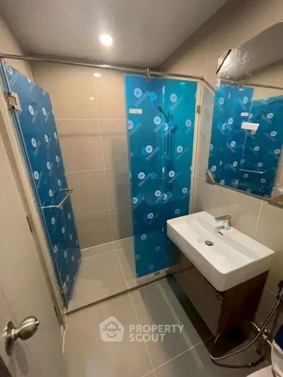 Modern bathroom with glass shower enclosure and sleek sink design