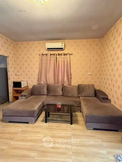 Cozy living room with modern sectional sofa and air conditioning, perfect for relaxation.