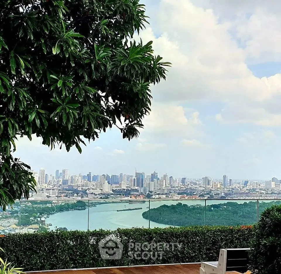 Stunning city skyline view from a lush rooftop garden with glass railing.