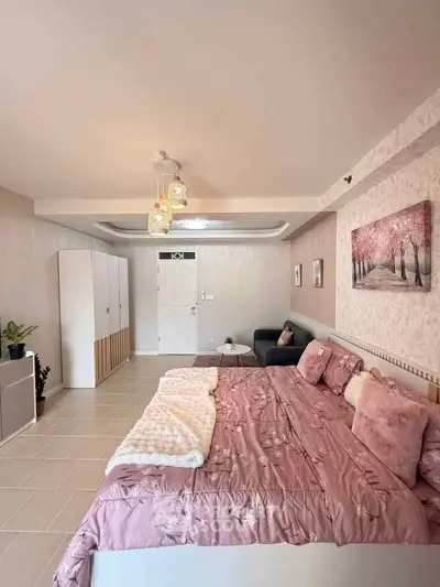 Spacious bedroom with elegant decor and cozy seating area, perfect for relaxation and comfort.