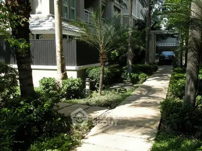 Charming garden pathway leading to a modern residential building entrance.