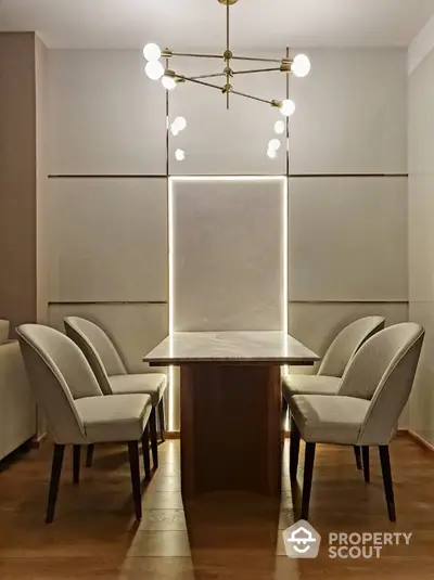 Elegant dining area with modern lighting and stylish chairs around a sleek table.