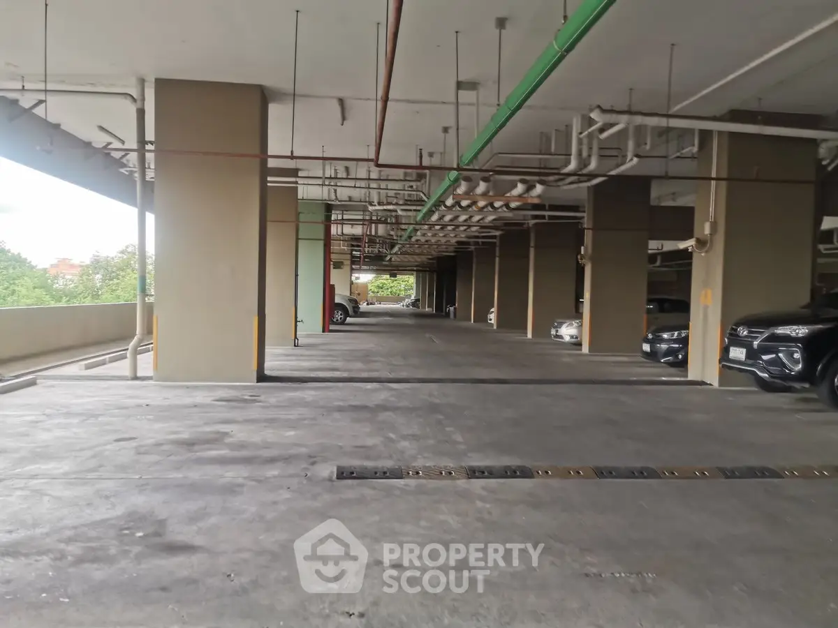 Spacious covered parking area with multiple vehicles and ample lighting.