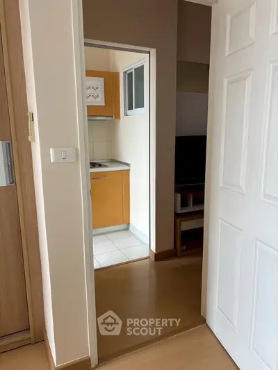 Cozy apartment interior with compact kitchen and wooden flooring