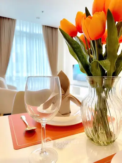 Elegant dining setup with tulips in modern living room, featuring bright natural light and stylish decor.