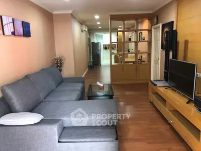 Spacious living room with modern gray sofa and wooden accents, perfect for relaxation and entertainment.