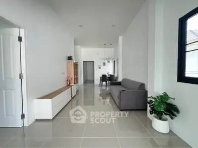 Spacious modern living room with sleek tile flooring and stylish furniture in a bright, airy setting.