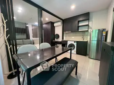Modern open-layout kitchen and dining area with sleek furniture and appliances.