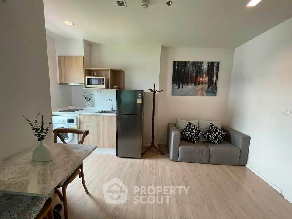 Modern open-layout kitchen and living area with stylish decor and natural light.
