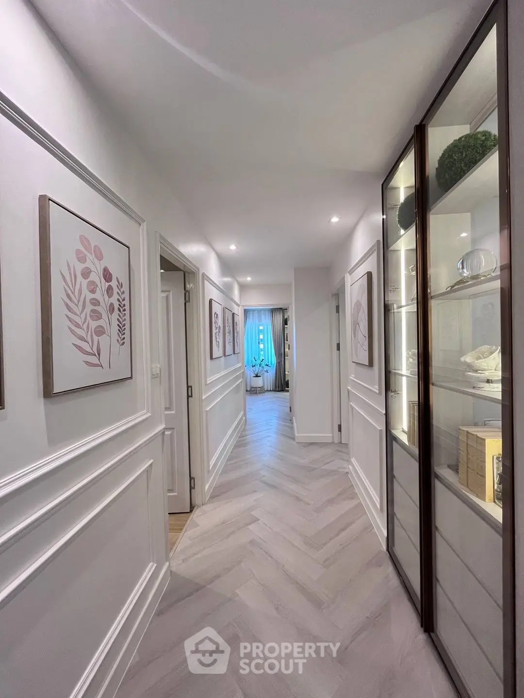 Elegant hallway with modern decor and stylish flooring leading to a bright room.