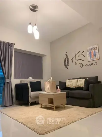Cozy living room with modern decor, plush rug, and stylish lighting, perfect for relaxation and entertaining.