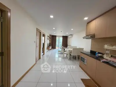 Spacious open-plan living room and kitchen with modern furnishings and natural light.