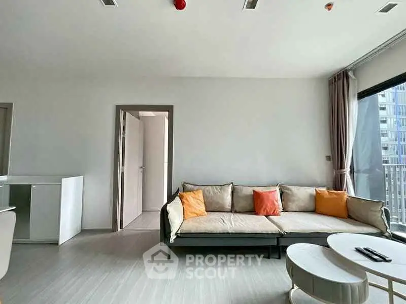 Modern living room with stylish sofa and large windows offering natural light.