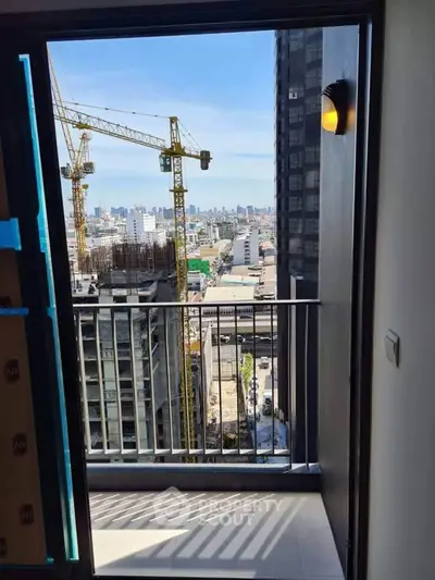 Modern balcony with city view and construction cranes in the background, perfect for urban living.