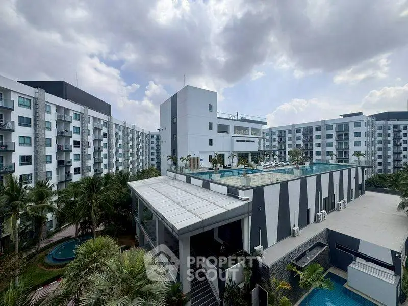 Modern apartment complex with rooftop pool and lush greenery, offering luxurious urban living.