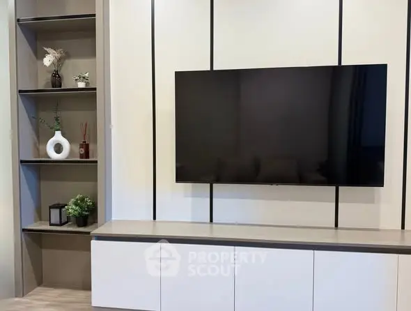 Modern living room with wall-mounted TV and stylish shelving