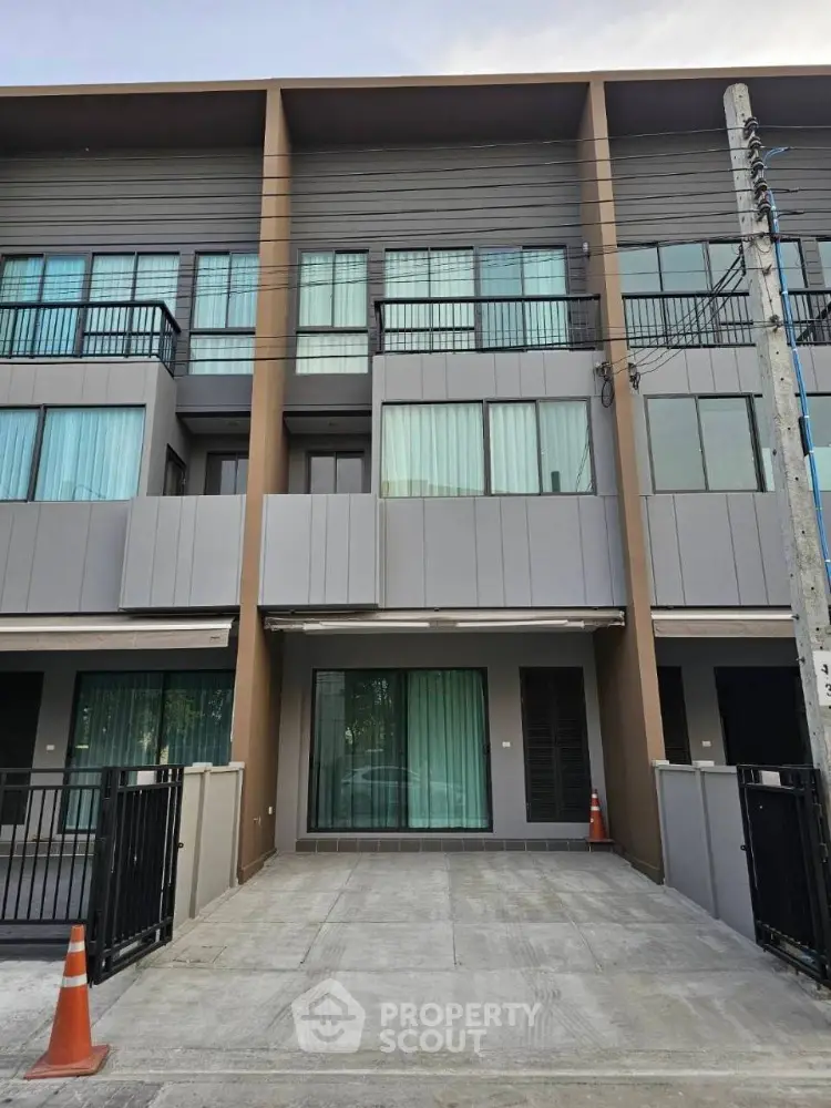 Modern townhouse exterior with sleek design and spacious driveway