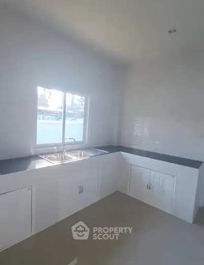 Bright modern kitchen with sleek countertops and dual sink, perfect for culinary enthusiasts.