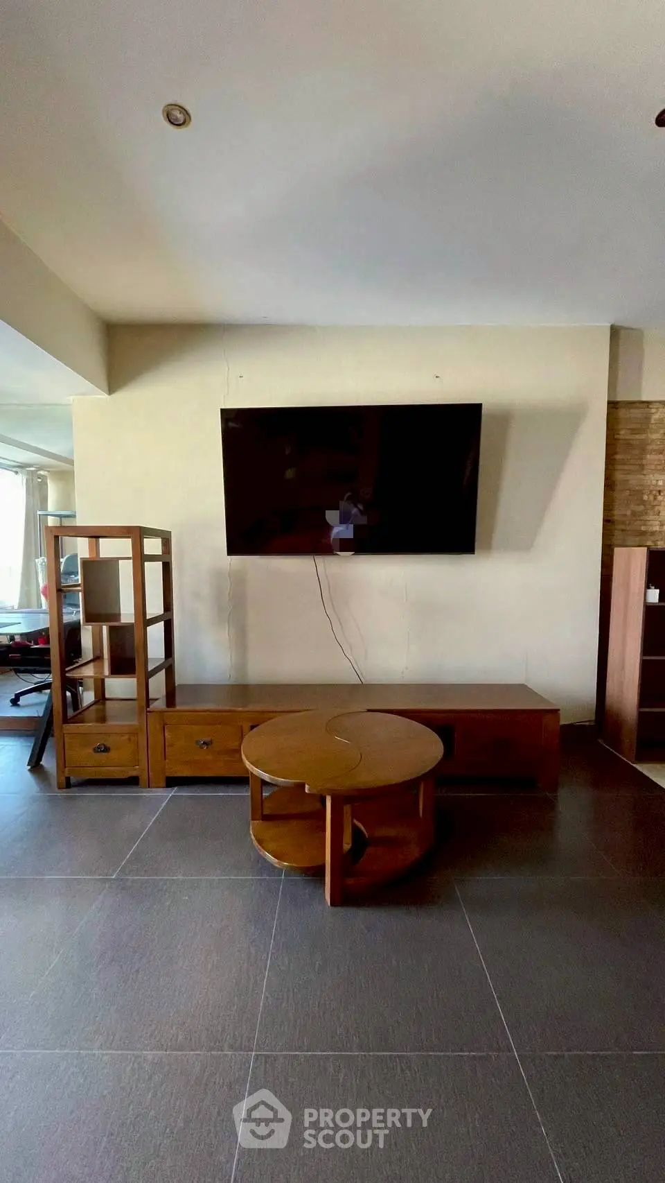 Spacious living room with modern TV setup and stylish wooden furniture