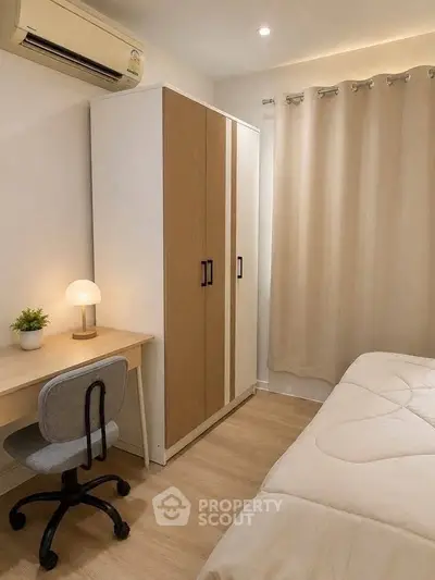 Cozy bedroom with modern furniture, featuring a desk, chair, wardrobe, and air conditioning.