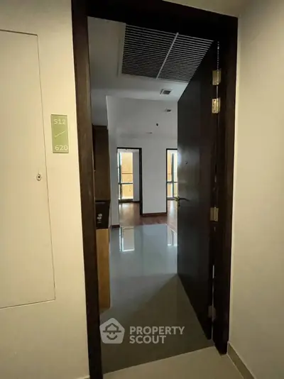 Modern apartment entrance with sleek wooden door and polished floors